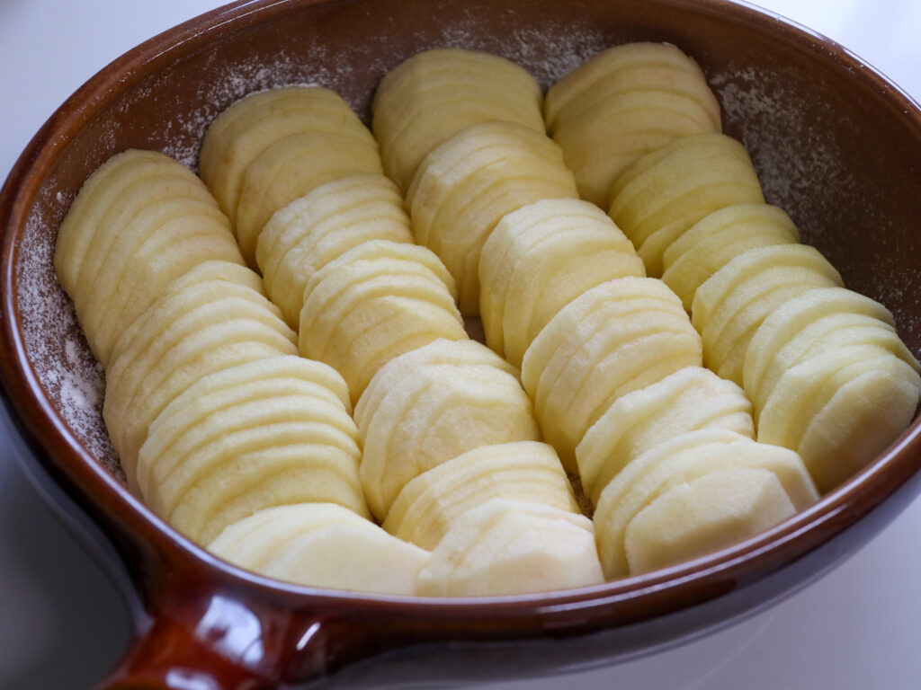 ガトーオポムレシピ　皮をむいて切ったりんごを薄切りにして耐熱容器に並べる